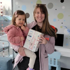 Mother and young daughter holding a prize box in the lobby